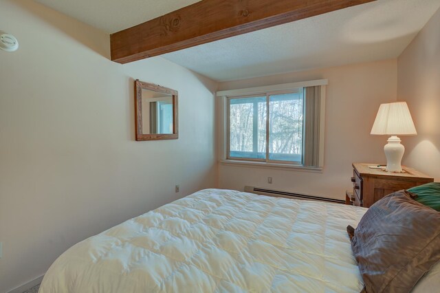 bedroom featuring baseboard heating and beam ceiling