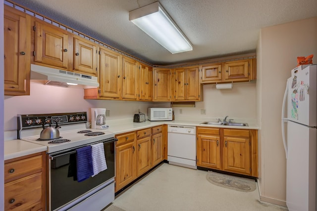 kitchen featuring a textured ceiling, under cabinet range hood, white appliances, a sink, and light countertops