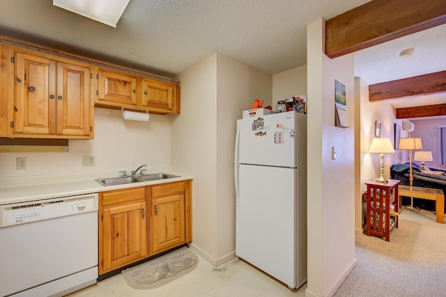 kitchen featuring a textured ceiling, white appliances, a sink, light countertops, and beamed ceiling