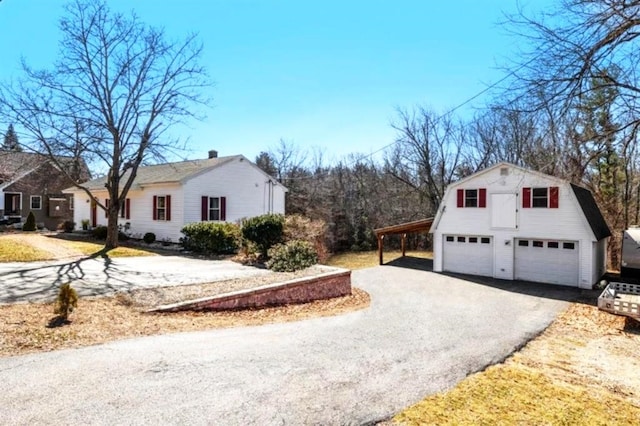 view of property exterior featuring an outdoor structure and a gambrel roof