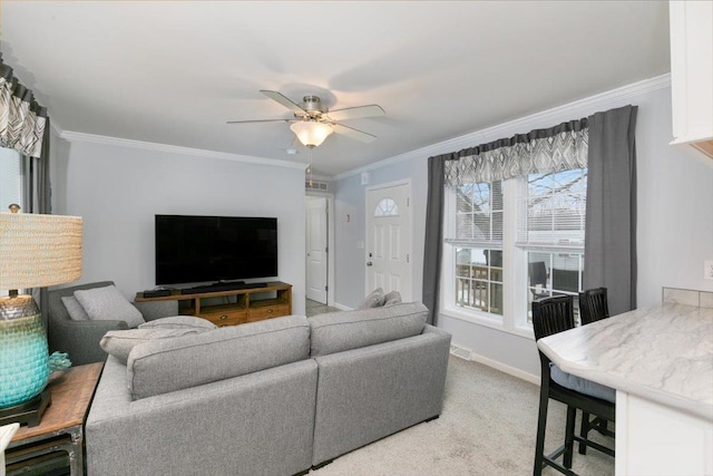 living area with light carpet, baseboards, a ceiling fan, and crown molding