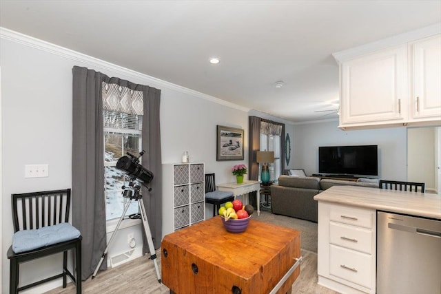 kitchen with crown molding, light countertops, light wood-style flooring, white cabinets, and dishwasher