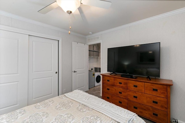 bedroom with crown molding, a closet, visible vents, a ceiling fan, and washer and dryer