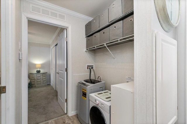 clothes washing area featuring ornamental molding, laundry area, washer / clothes dryer, and visible vents