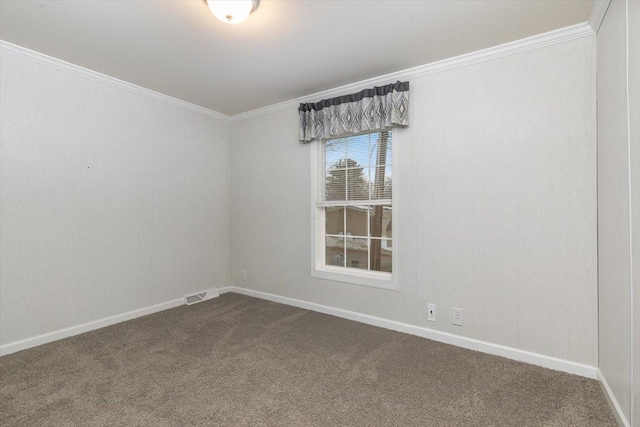 empty room featuring dark colored carpet, ornamental molding, visible vents, and baseboards