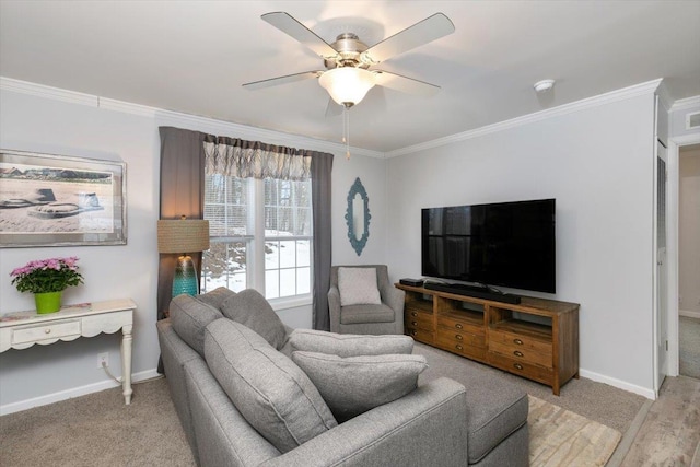 living area featuring visible vents, a ceiling fan, baseboards, ornamental molding, and light wood finished floors