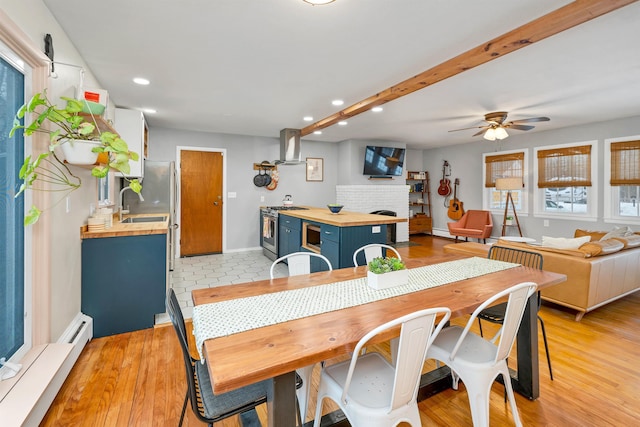 dining area with light wood-style floors, recessed lighting, and a fireplace