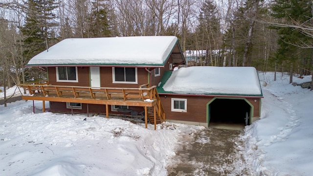 view of front of property with a garage, stairs, a deck, and an outbuilding