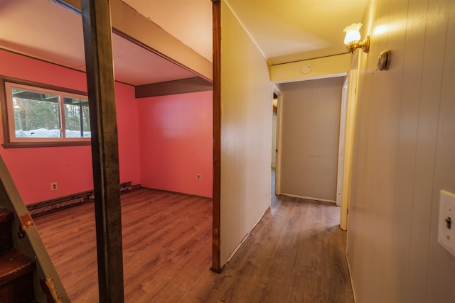 hallway with wooden walls, beam ceiling, and wood finished floors