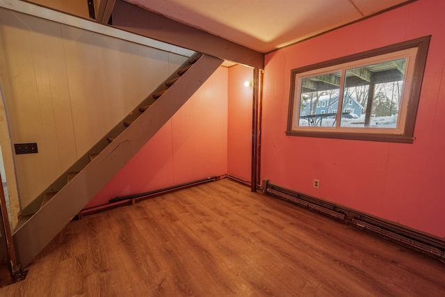 spare room featuring stairway and light wood-style flooring