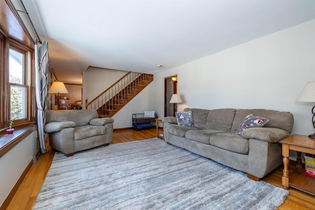 living area featuring stairway and wood finished floors