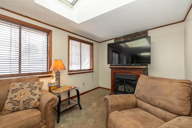 carpeted living area with a skylight, a fireplace, baseboards, and crown molding