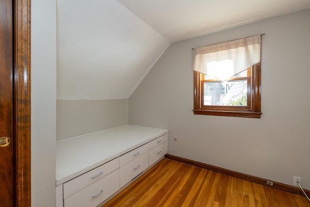 interior space with vaulted ceiling, light wood-style flooring, and baseboards