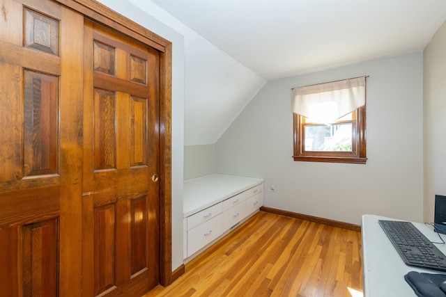 bonus room featuring light wood finished floors, baseboards, and vaulted ceiling