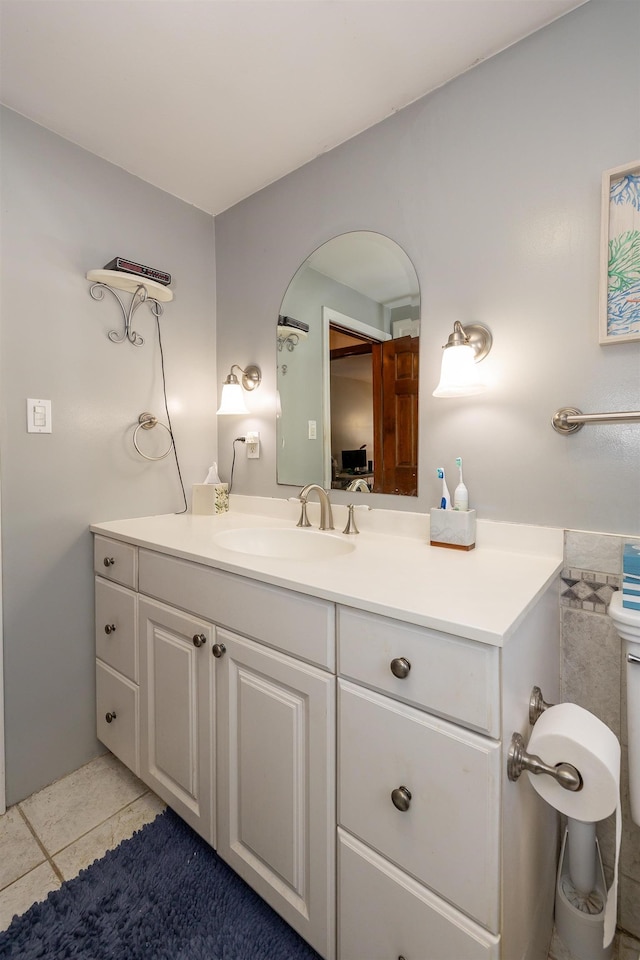 bathroom with toilet, vanity, and tile patterned floors