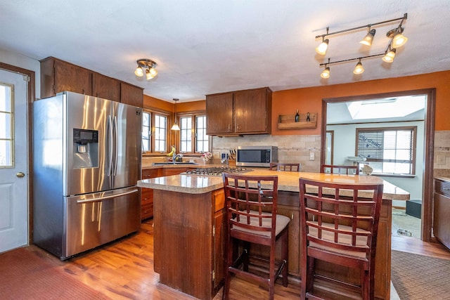 kitchen featuring light countertops, appliances with stainless steel finishes, plenty of natural light, and a sink