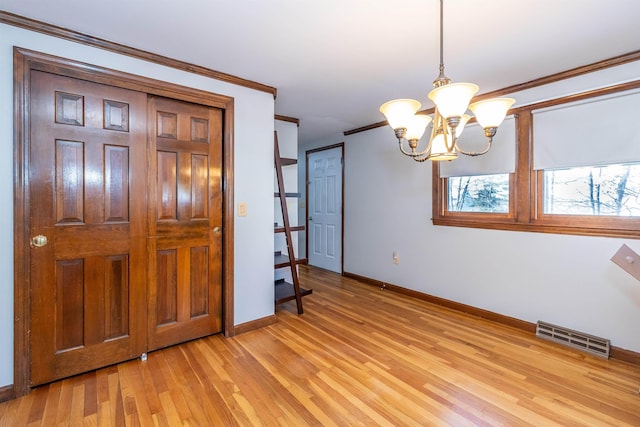 interior space featuring light wood-style flooring, a notable chandelier, visible vents, baseboards, and crown molding