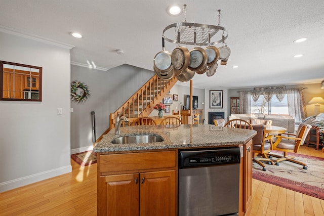 kitchen featuring a sink, stone counters, light wood-type flooring, and stainless steel dishwasher