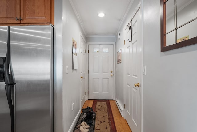 doorway to outside featuring light wood-style floors, baseboards, and crown molding