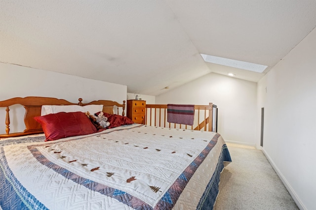 carpeted bedroom with vaulted ceiling with skylight and baseboards