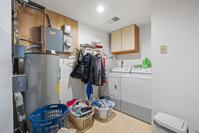 clothes washing area featuring visible vents, water heater, cabinet space, light floors, and washer and clothes dryer