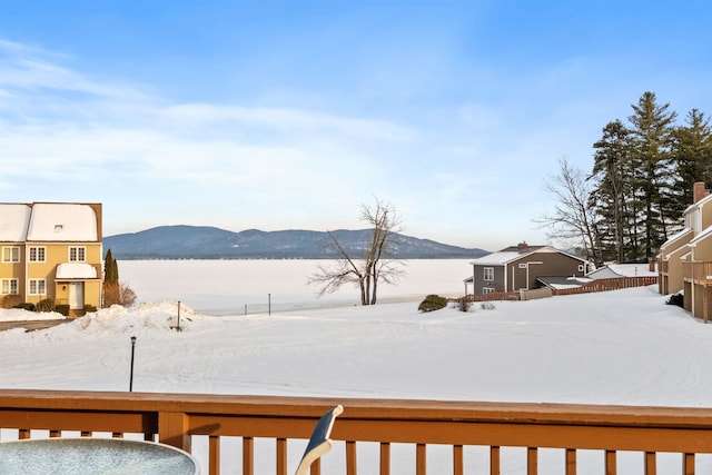 yard covered in snow featuring a mountain view