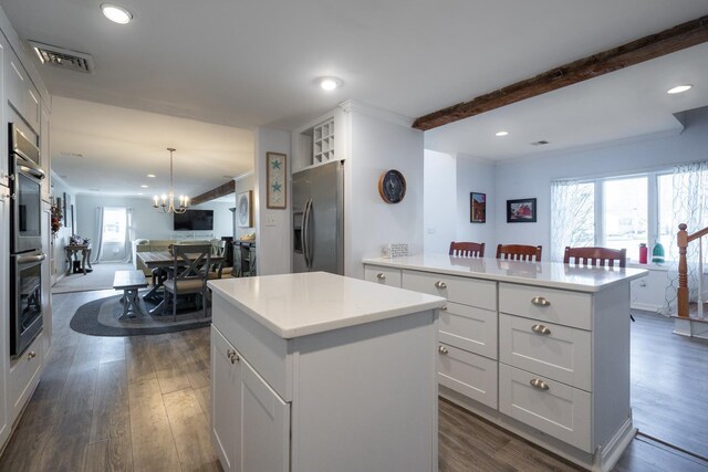 kitchen featuring dark wood-style floors, visible vents, appliances with stainless steel finishes, open floor plan, and a kitchen island