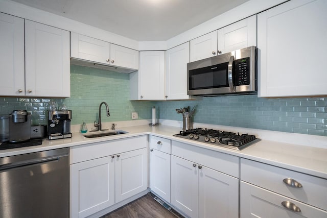 kitchen featuring white cabinets, stainless steel appliances, a sink, and light countertops