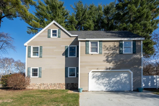 view of front of house featuring a garage, driveway, and a front yard