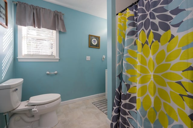 bathroom with toilet, curtained shower, baseboards, and tile patterned floors