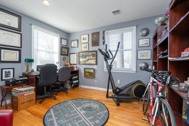 office area featuring baseboards, visible vents, a wealth of natural light, and wood finished floors