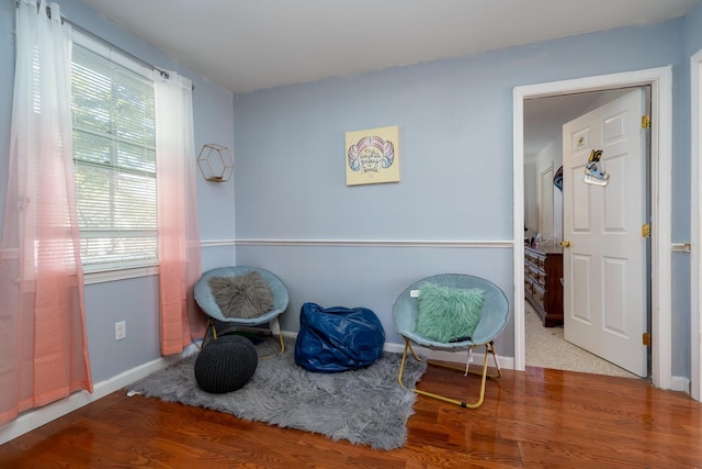 living area with wood finished floors and baseboards