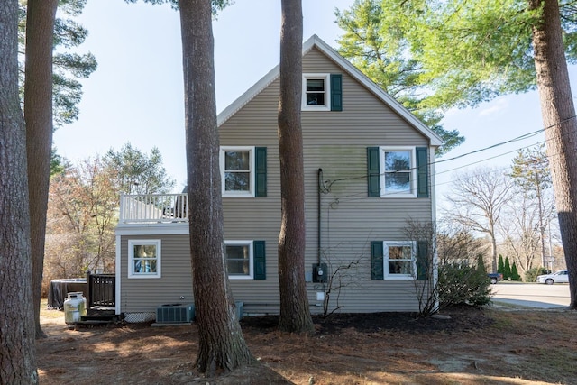 rear view of property featuring central AC unit and a balcony