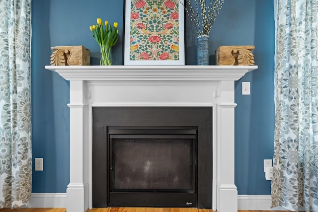 interior details featuring a glass covered fireplace and baseboards