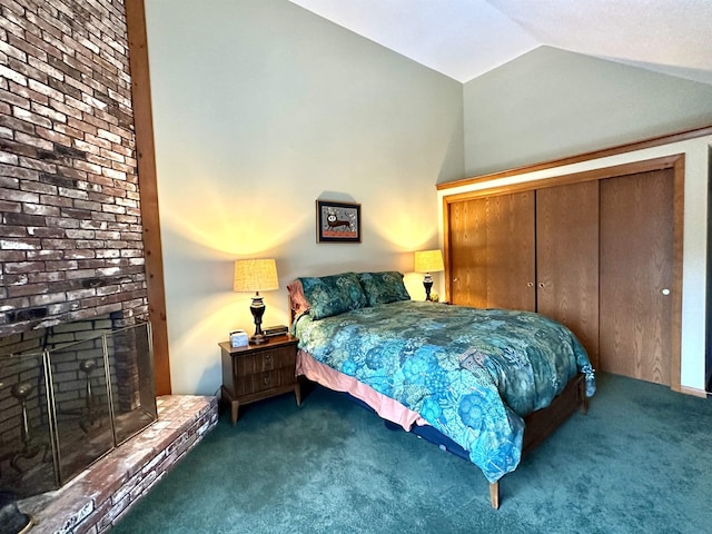 bedroom featuring vaulted ceiling, a closet, carpet, and a fireplace