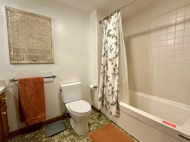 bathroom featuring toilet, baseboards, shower / bath combo with shower curtain, and vanity