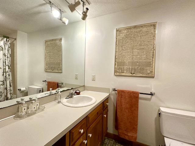 bathroom with curtained shower, a textured ceiling, toilet, and vanity