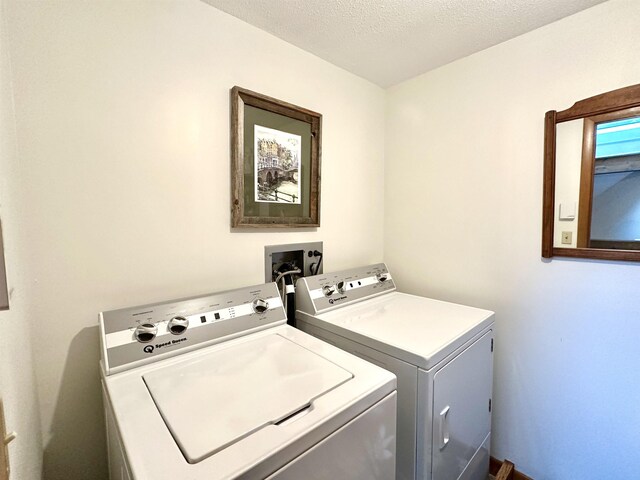 laundry area featuring a textured ceiling, laundry area, and washing machine and clothes dryer