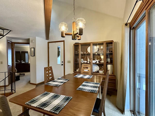 dining area with carpet, lofted ceiling with beams, a textured ceiling, a chandelier, and baseboards