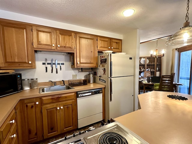 kitchen with brown cabinetry, white appliances, light countertops, and a sink