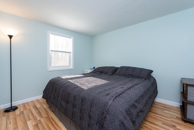 bedroom featuring light wood-style flooring and baseboards