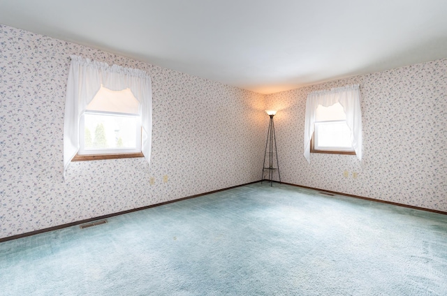 carpeted spare room with baseboards, visible vents, and wallpapered walls