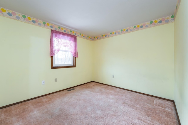 empty room with baseboards, visible vents, and carpet flooring