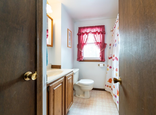 bathroom with baseboards, vanity, toilet, and tile patterned floors