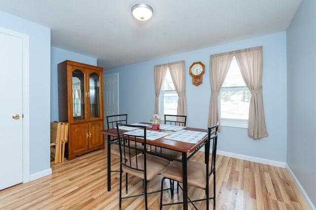 dining room with light wood-type flooring and baseboards