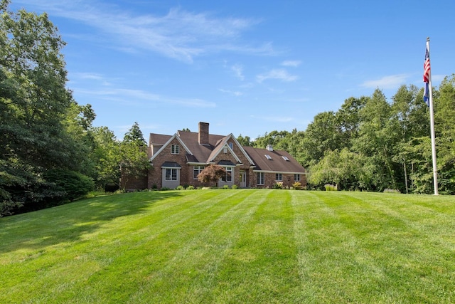 rear view of property with a chimney and a yard