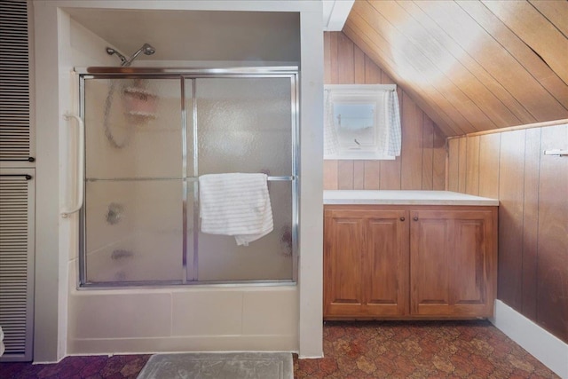 full bath featuring lofted ceiling, combined bath / shower with glass door, and wood walls