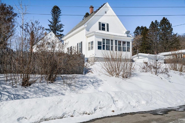 exterior space featuring a sunroom and a chimney