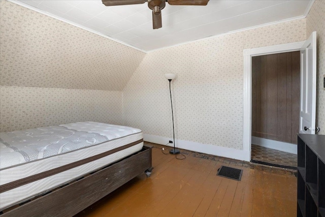 bedroom with crown molding, visible vents, a ceiling fan, hardwood / wood-style floors, and wallpapered walls