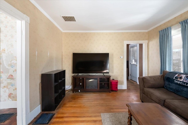 living room featuring light wood-style floors, a wealth of natural light, visible vents, and wallpapered walls